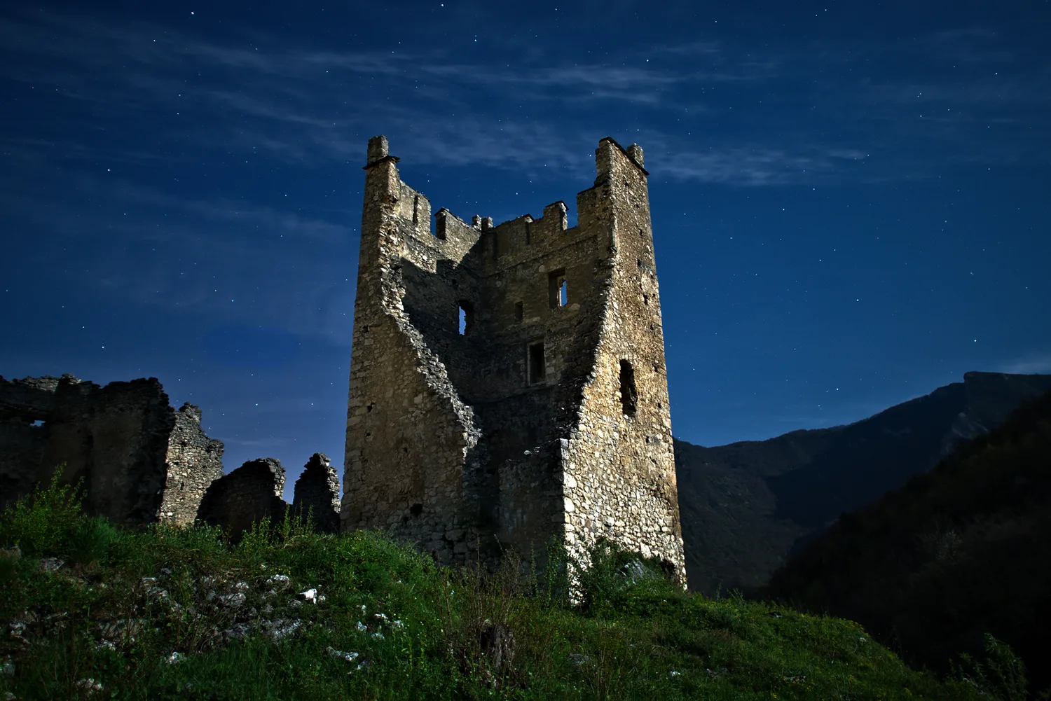 Le château de Miglos en Ariège photographié de nuit sous la pleine lune.
